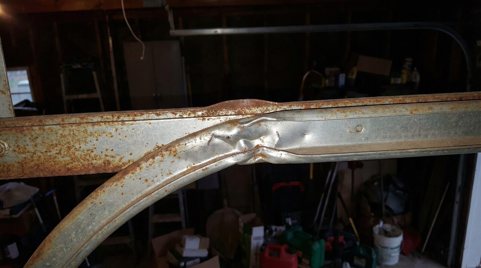 close-up of garage door track showing bent or damaged rail